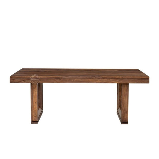 A rectangular wooden dining table with a medium-to-dark brown wood grain finish, featuring thick block-style legs, shown against a plain white background.