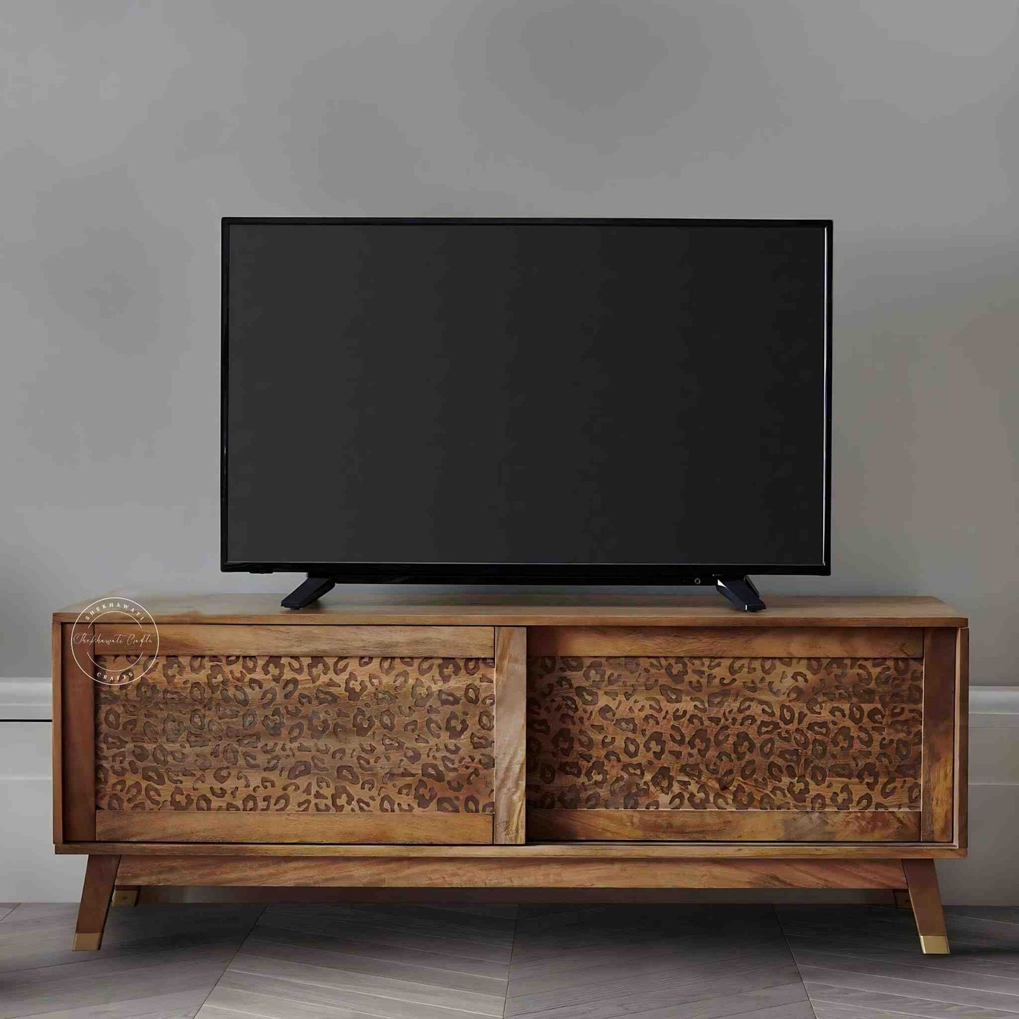 The Aarika handcrafted wooden TV cabinet is made from mango wood and features sliding doors.