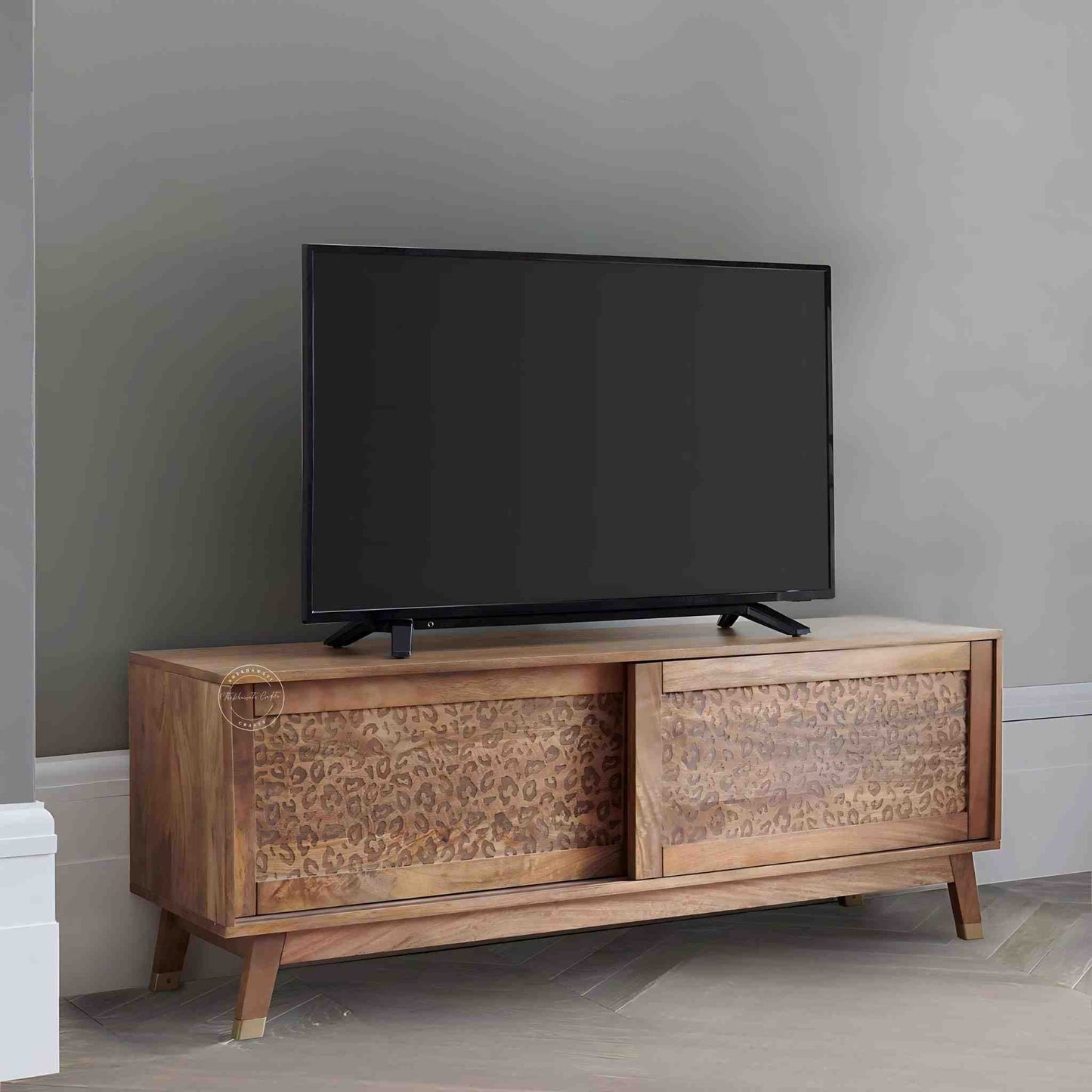 The Aarika handcrafted wooden TV cabinet is made from mango wood and features sliding doors.