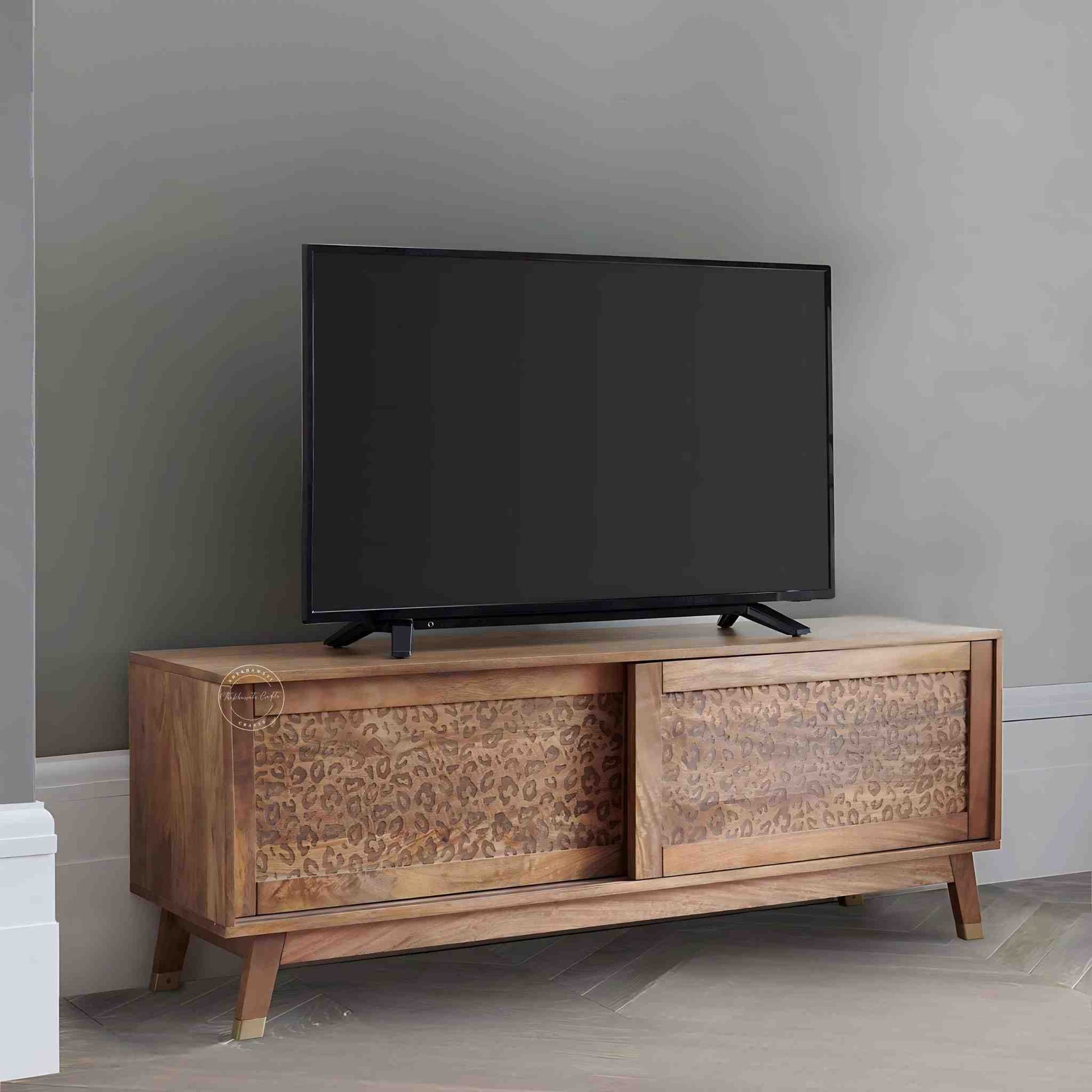 The Aarika handcrafted wooden TV cabinet is made from mango wood and features sliding doors.