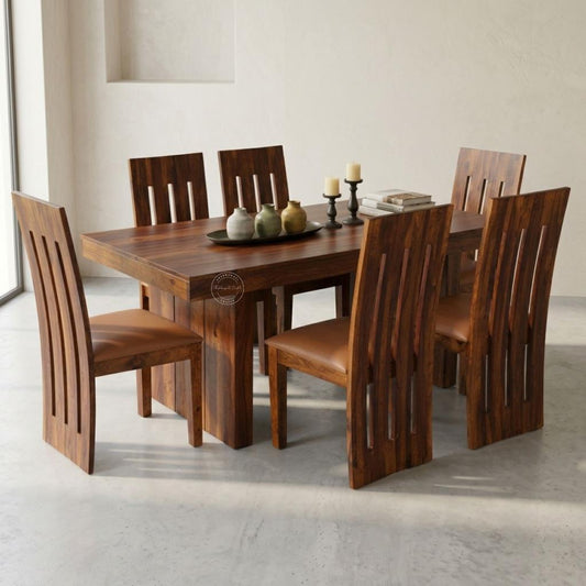 A wooden dining table set with six matching chairs, featuring a honey finish and vertical slat backs, styled with decorative vases.