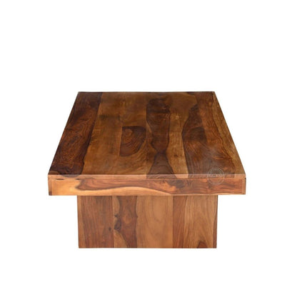 A rectangular sheesham wood centre table with a thick, raised apron base and a rich, warm brown wood grain finish, shown against a plain white background.