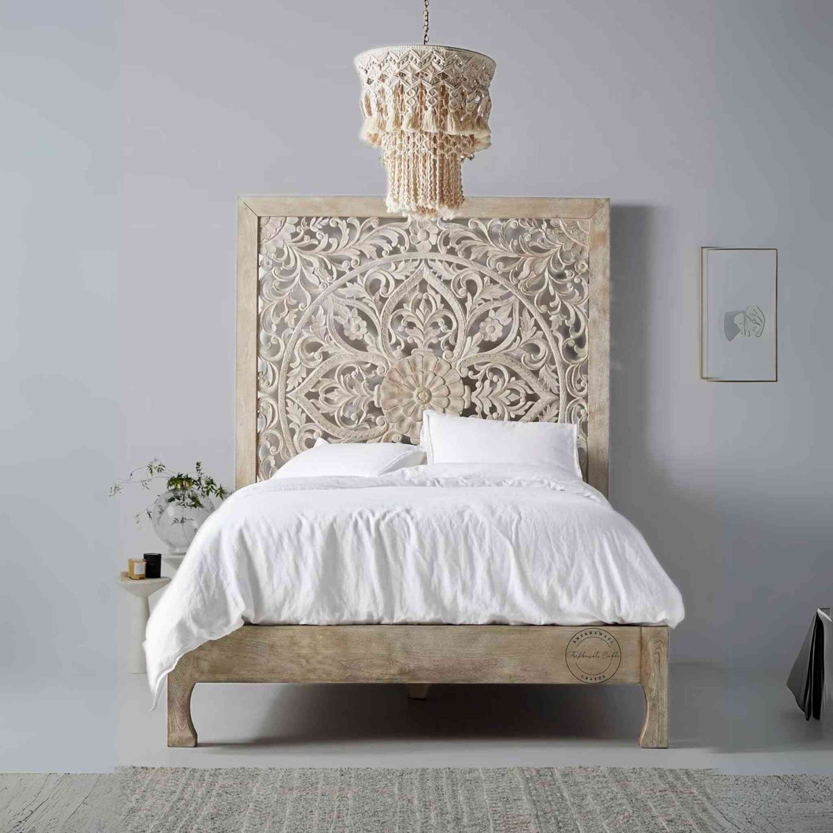 A king-size wooden bed with hand carvings on the headboard, painted in a rustic white finish.