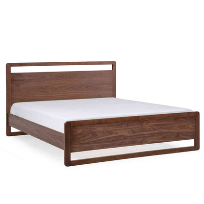 side view of a king-size bed made of Sheesham wood with a headboard and footboard in white background.