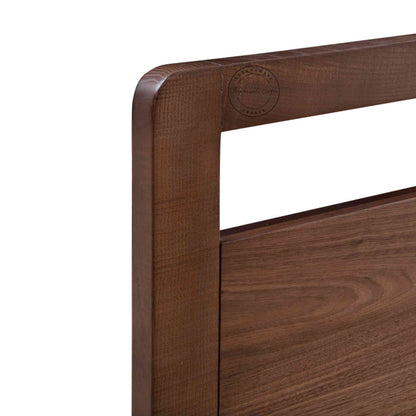 Close up view of a king-size bed made of Sheesham wood with a headboard in white background.