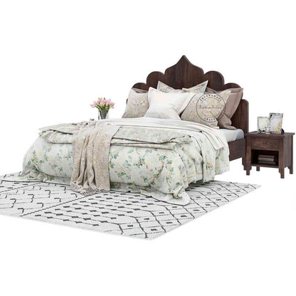 A king size Brassico bed made of Sheesham wood with a walnut finish, featuring a floral bedsheet in a white background.