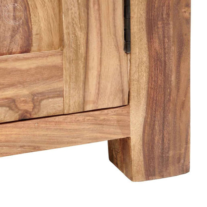 Close-up of a wooden cabinet corner showing natural wood grain, a dark metal hinge, and a block-style leg on a white background.