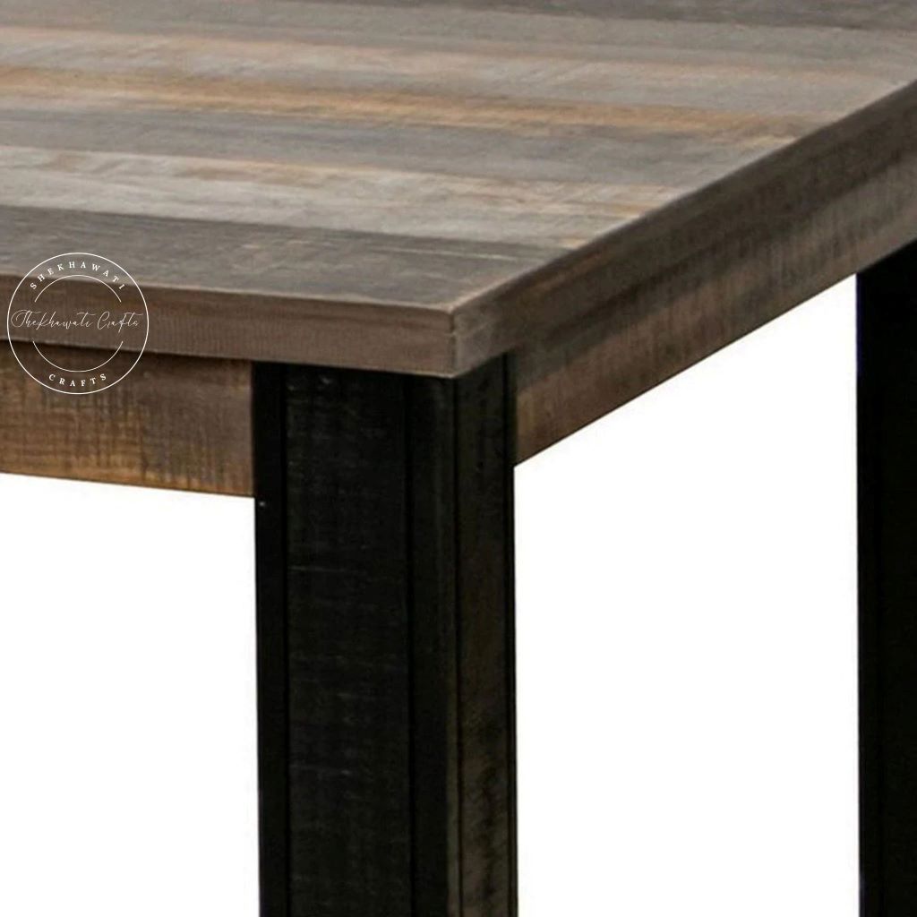 Close-up of a rustic wooden table corner with a weathered brown tabletop and dark wooden legs against a white background.