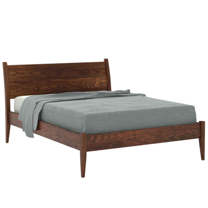 Side view of a king size bed made of Sheesham wood with a curved headboard, shown in a white background.