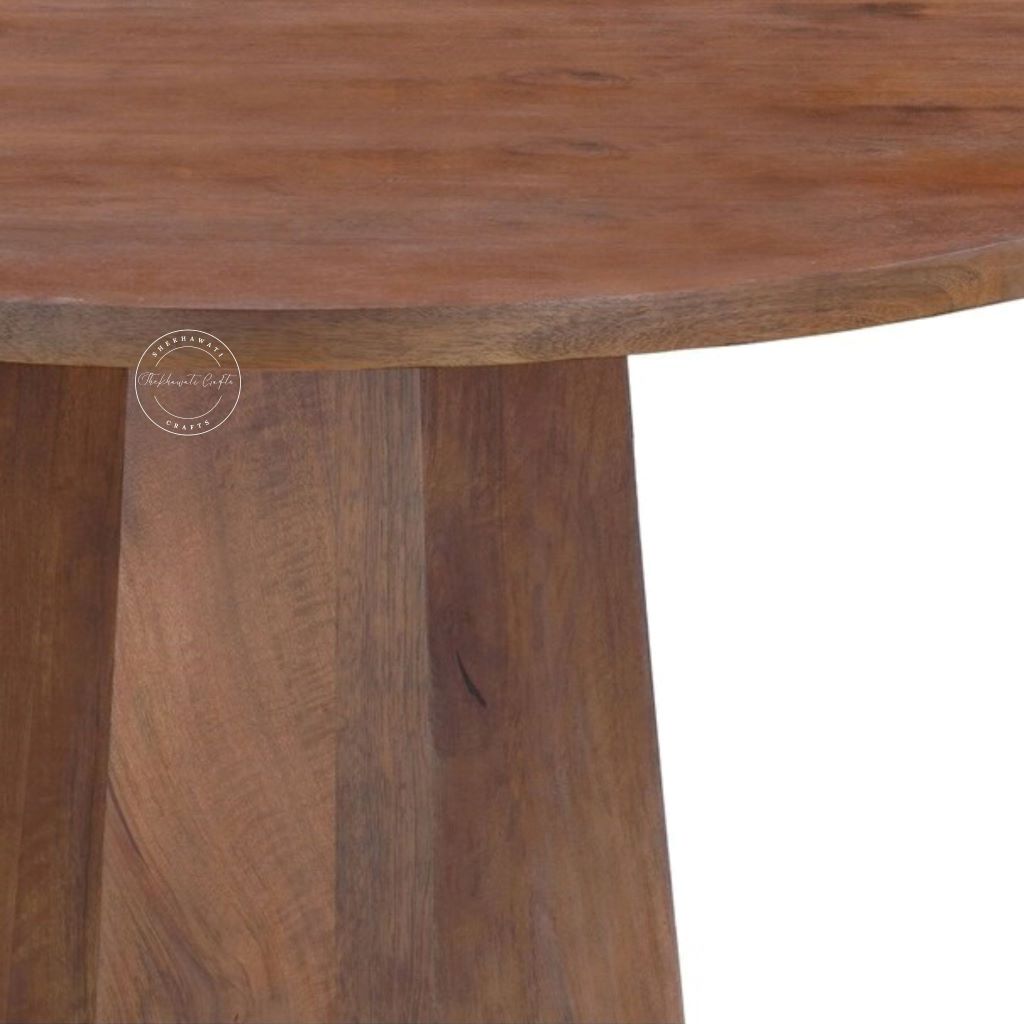 Close-up of a round wooden table with a thick, curved top and a sturdy pedestal base, showcasing a warm medium-brown wood grain finish.