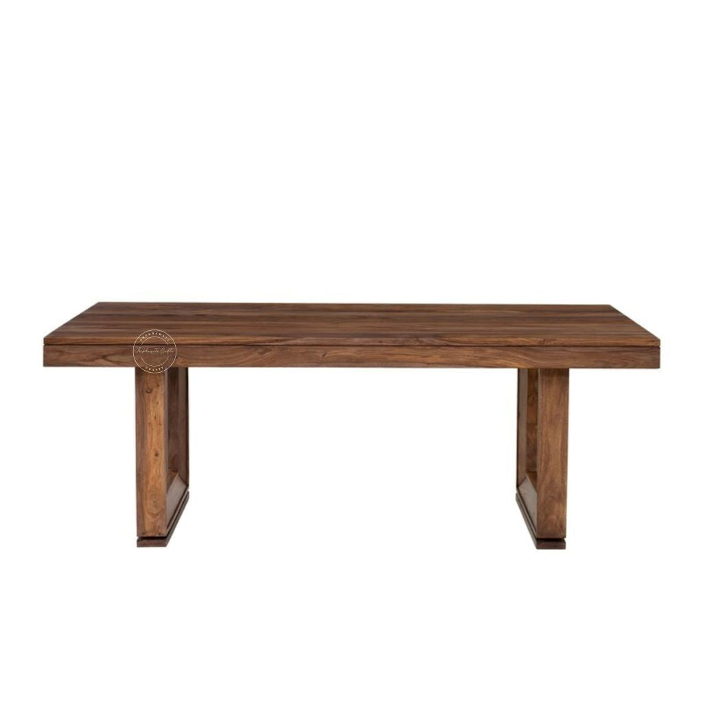 A rectangular wooden dining table with a medium-to-dark brown wood grain finish, featuring thick block-style legs, shown against a plain white background.