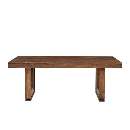 A rectangular wooden dining table with a medium-to-dark brown wood grain finish, featuring thick block-style legs, shown against a plain white background.