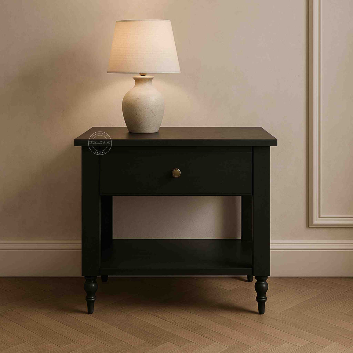 Black nightstand with a white lamp on a wooden floor against a beige wall.