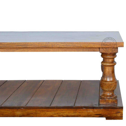 New City Center Table is made from Sheesham wood with a honey finish, antique-inspired design and bottom shelf storage.