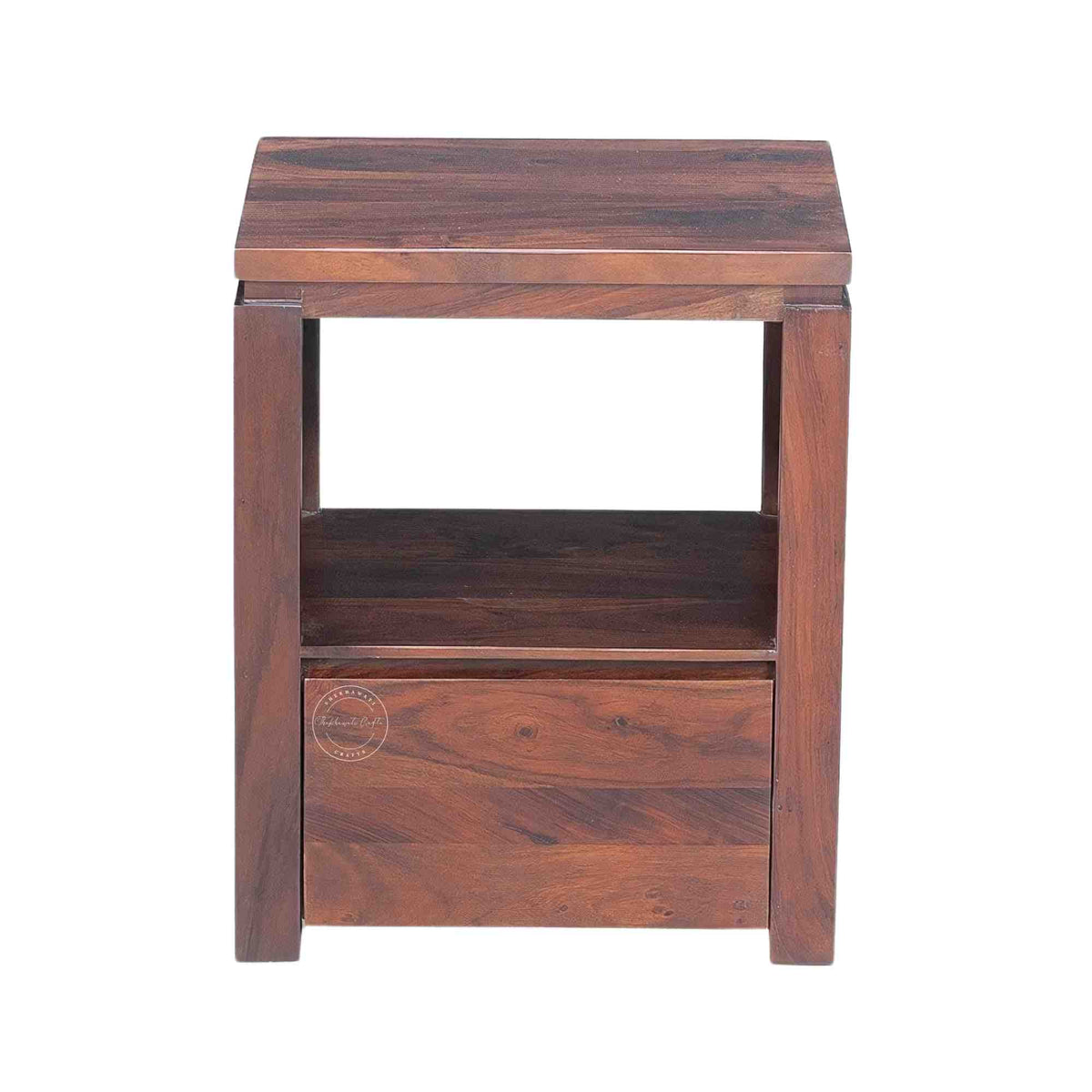 A wooden bedside table made of sheesham wood with a honey finish, featuring a drawer and an open shelf.