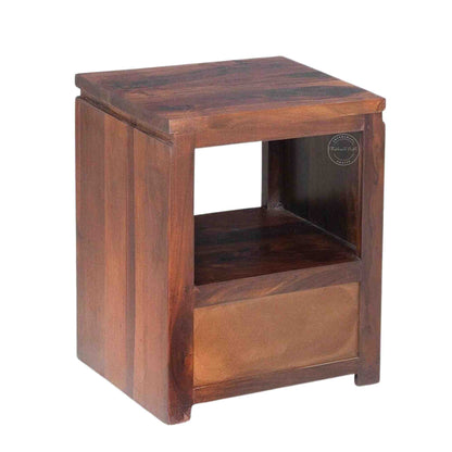 Back side view of a wooden bedside table made of sheesham wood with a honey finish, featuring a drawer and an open shelf.