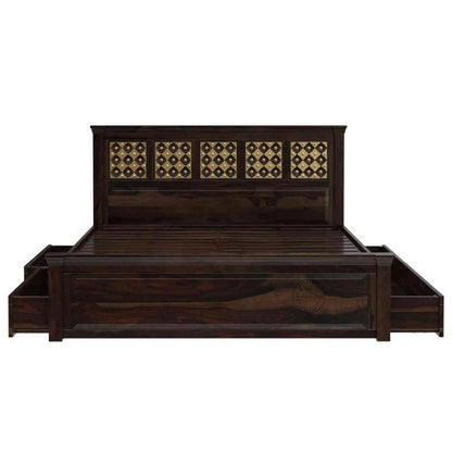A king size wooden bed with brass inlays and storage drawers, in a room with light walls.