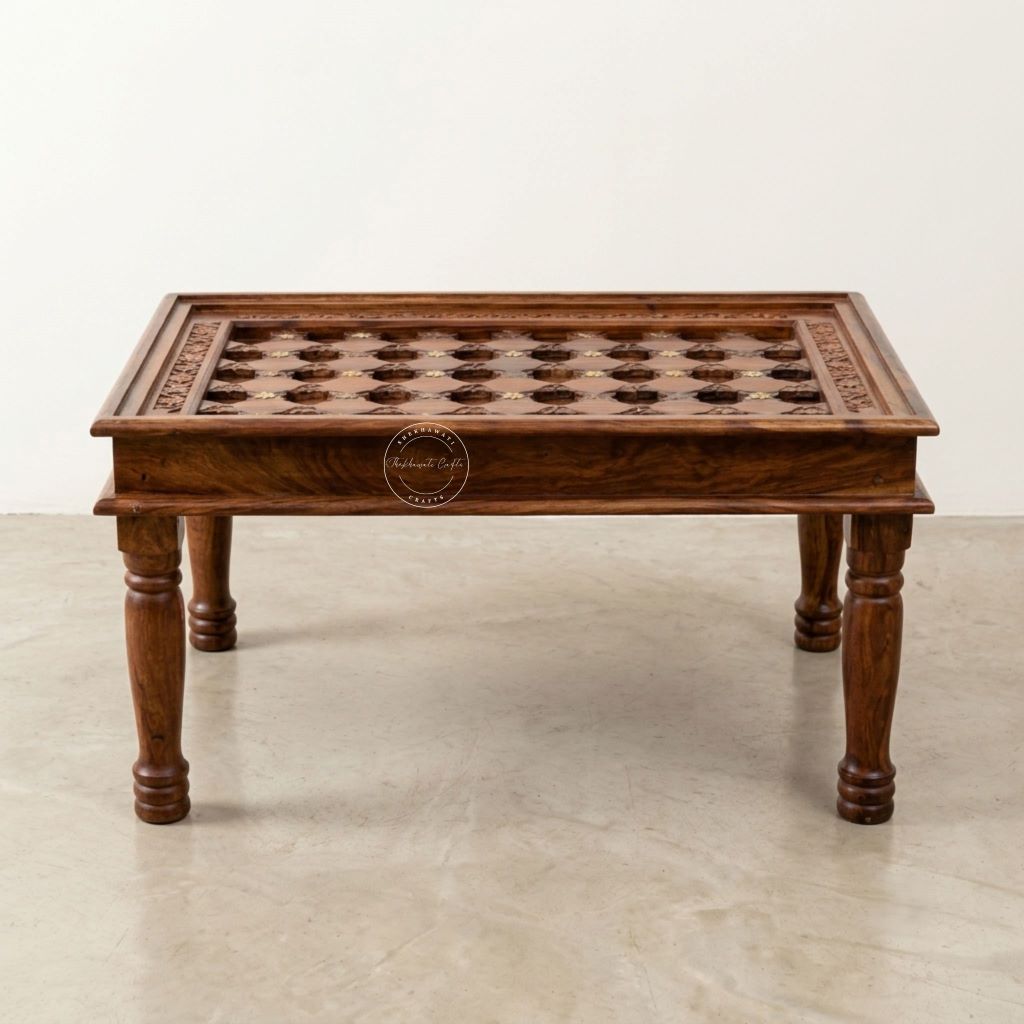 A rectangular wooden coffee table with hand-carved details on top, turned legs, and a warm medium-brown finish.