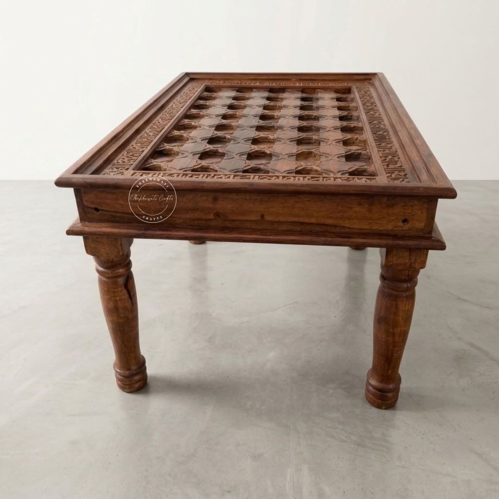 A dark brown carved wooden table with a grid-patterned top and turned legs.