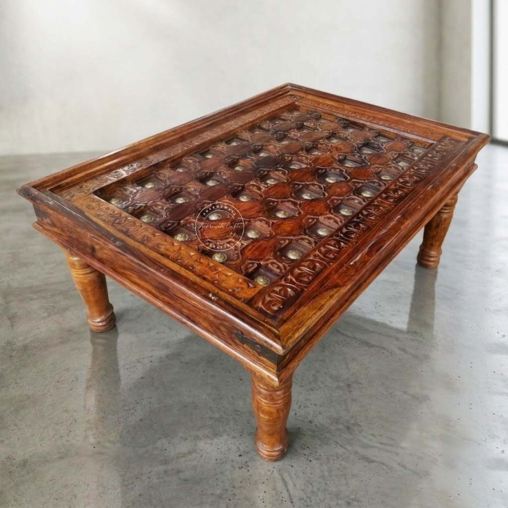 A square wooden table with carved and inlaid detailing on the tabletop, featuring turned legs and a warm reddish-brown finish.