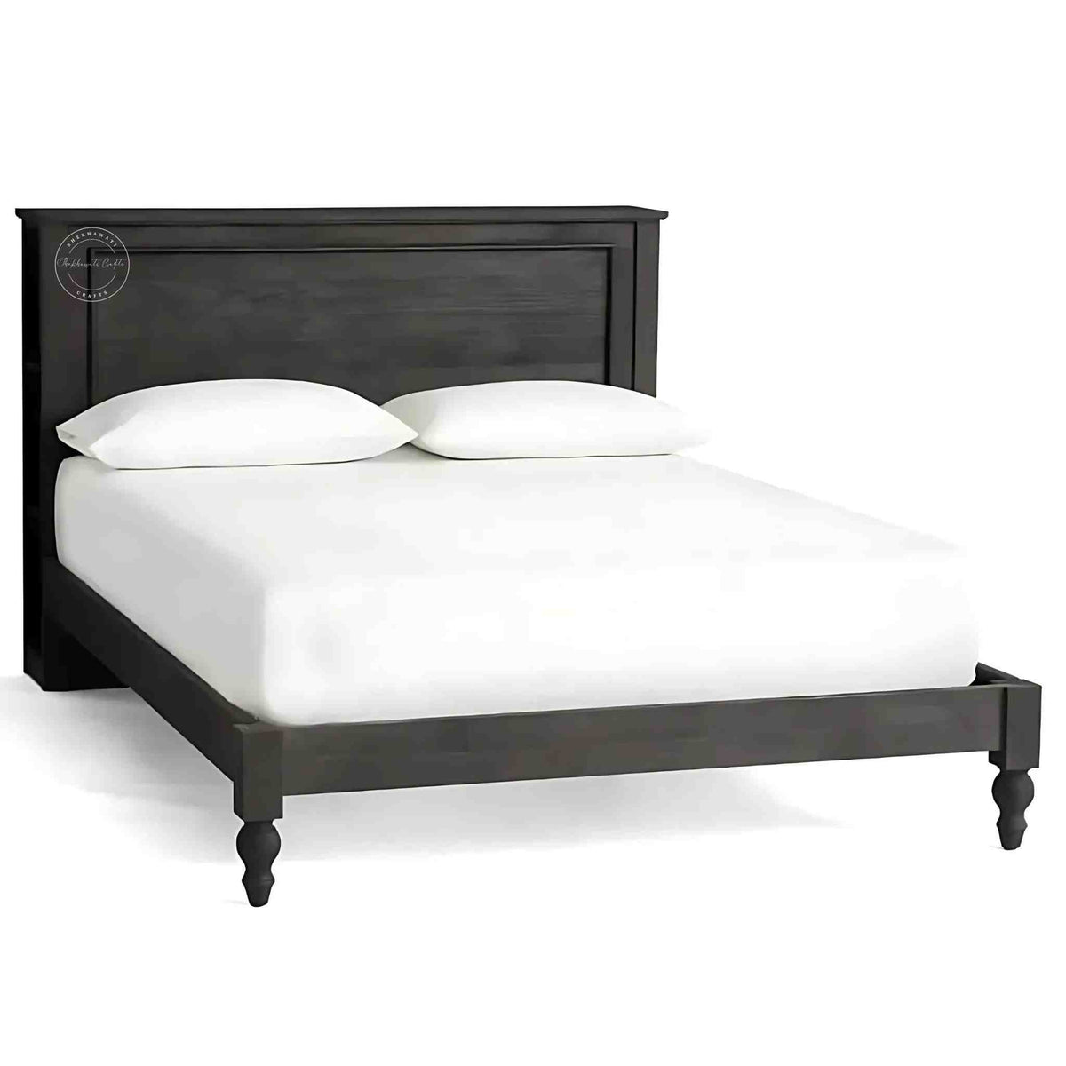 A wooden king size bed with a dark wooden headboard and footboard, dressed with white bedding.