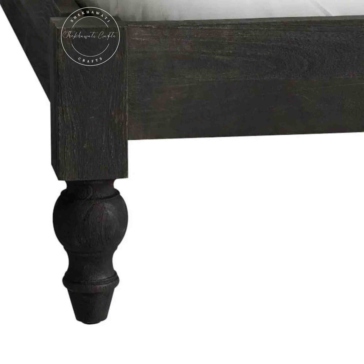 Close-up view of a wooden king size bed footboard and round leg.