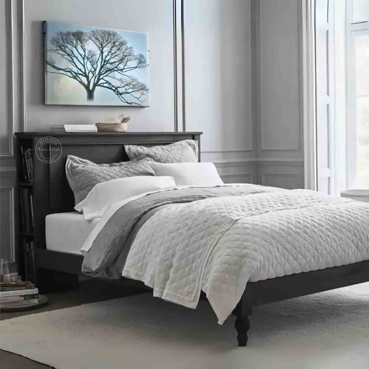 A wooden king size bed with a dark wooden headboard and footboard, dressed with white and gray bedding, set in a room with light walls.
