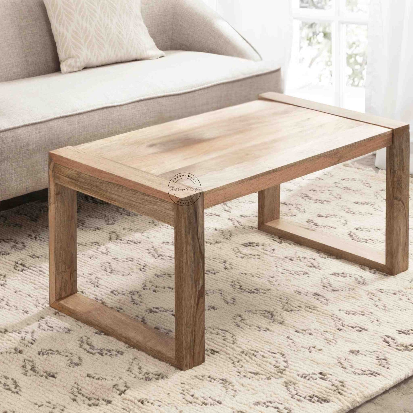 Travis Center Table is handcrafted from mango wood and features a natural finish with foldable legs.