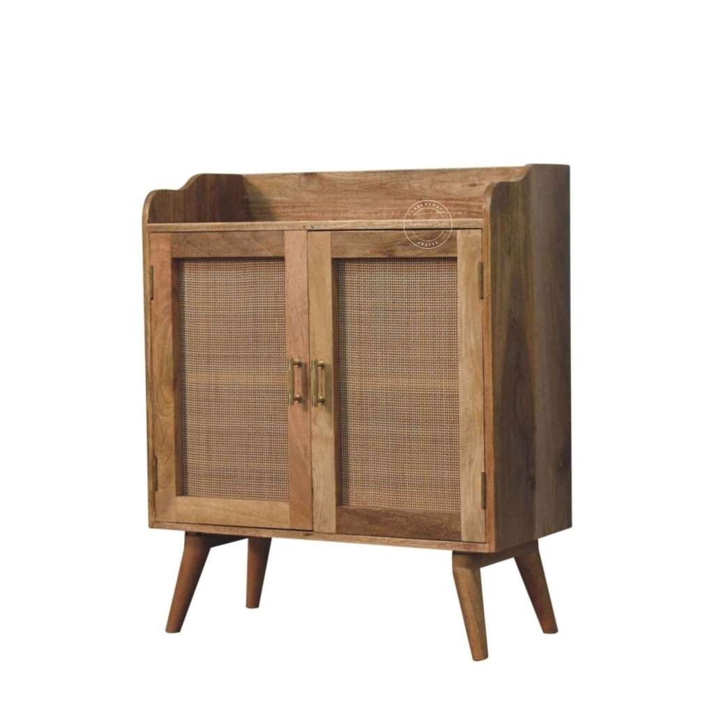A mid-century modern wooden cabinet with two doors featuring woven cane panels, brass handles, and tapered wooden legs, shown against a plain white background.